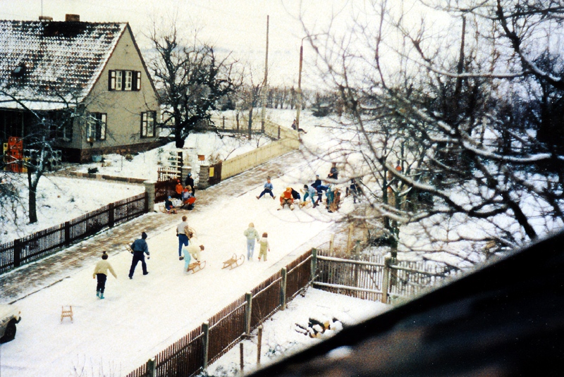 Rodelnde Kinder auf der verschneiten Wehrstraße