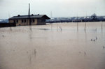 Sportplatz mit Sportlerheim bei Hochwasser. 